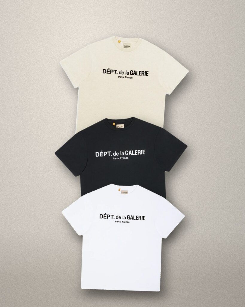 T-shirt Gallery Dept. French Logo crema, nere e bianche impilate su fondale in pietra